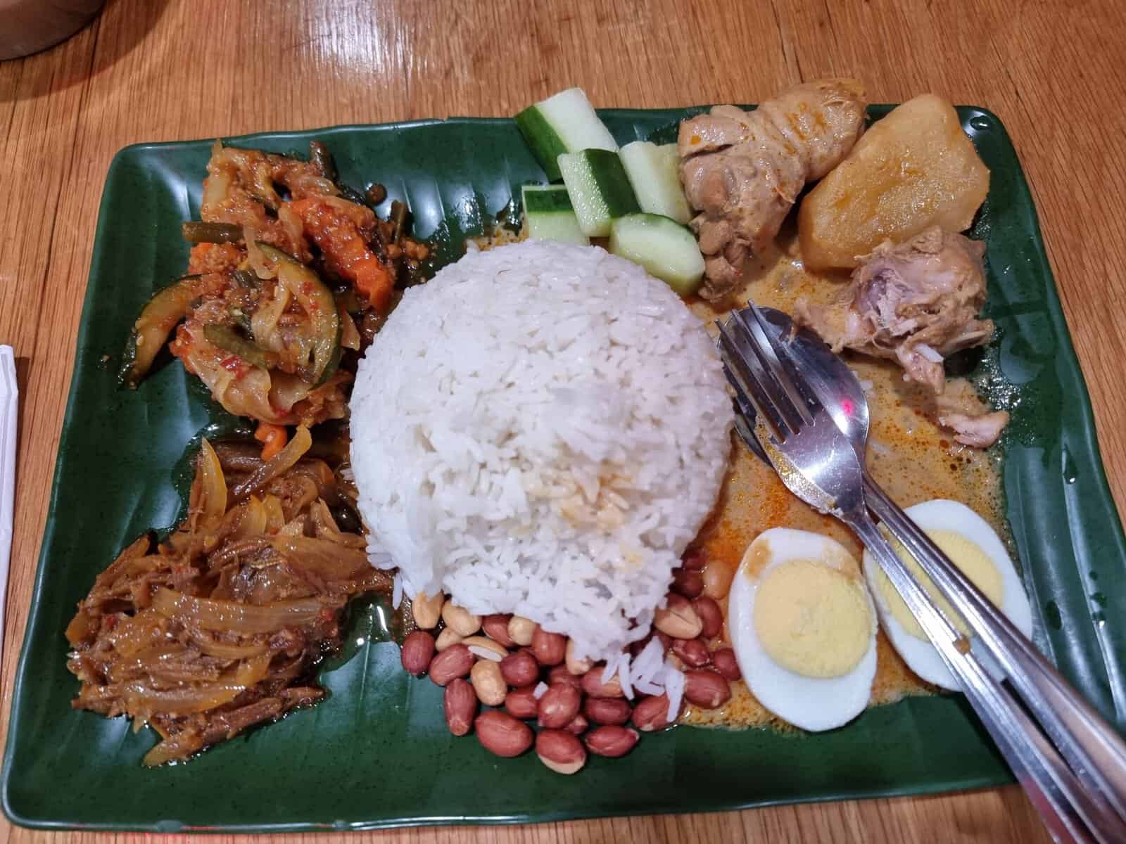 Authentic Nasi Lemak with coconut rice, sambal, hard-boiled egg, and fried anchovies at Taste Good Elmhurst