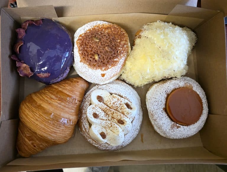 Overhead shot of a cardboard box filled with six assorted Filipino-inspired pastries from Kora Bakery.