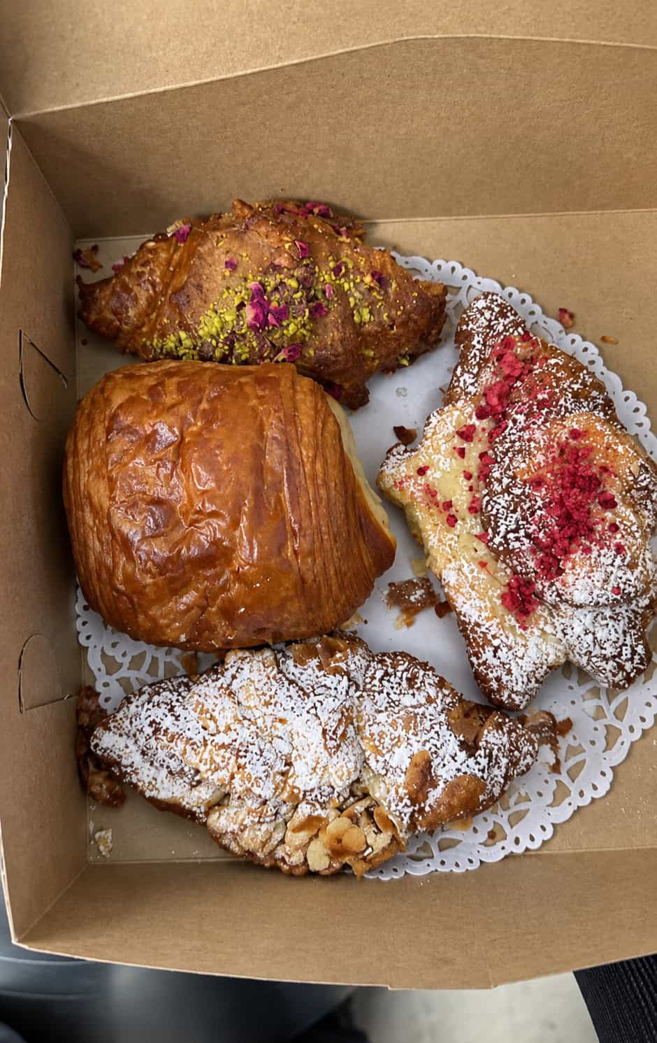 Box of pistachio, almond chocolate, raspberry, and pain au chocolat pastries from L'Appartement 4F