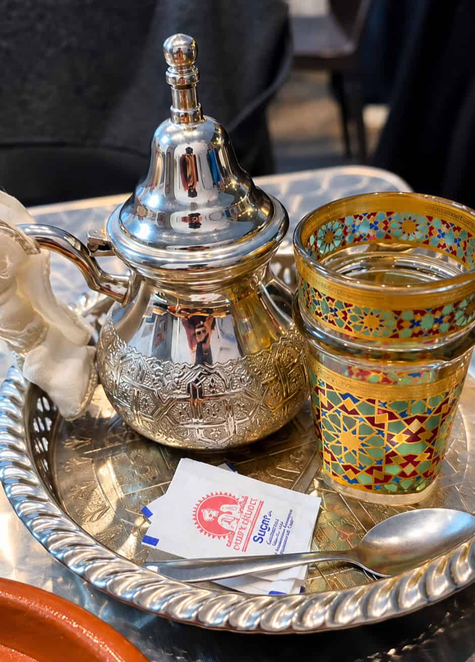 Moroccan mint tea served in a traditional metal teapot and decorative glass