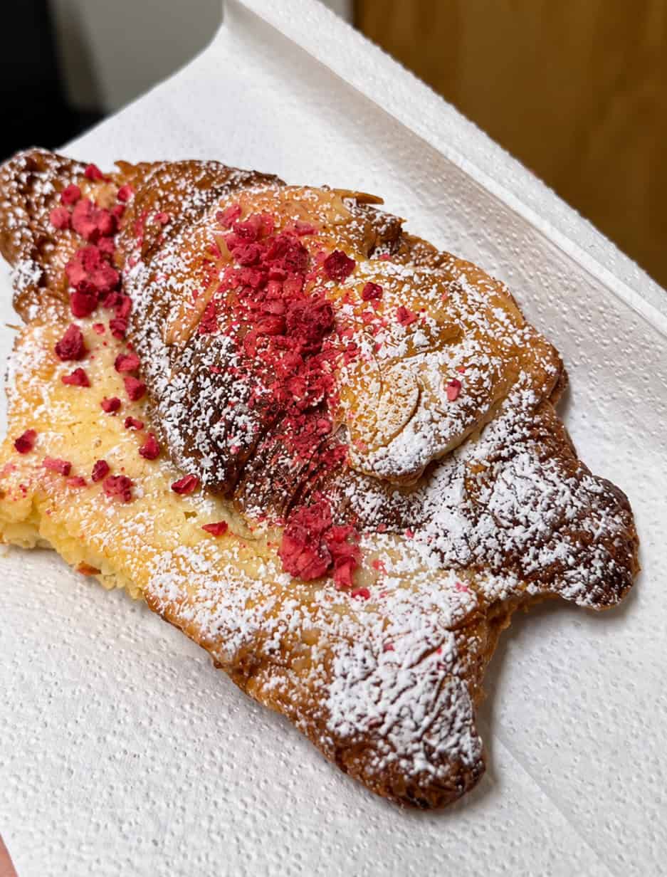 Raspberry croissant topped with powdered sugar and raspberry pieces at L'Appartement 4F