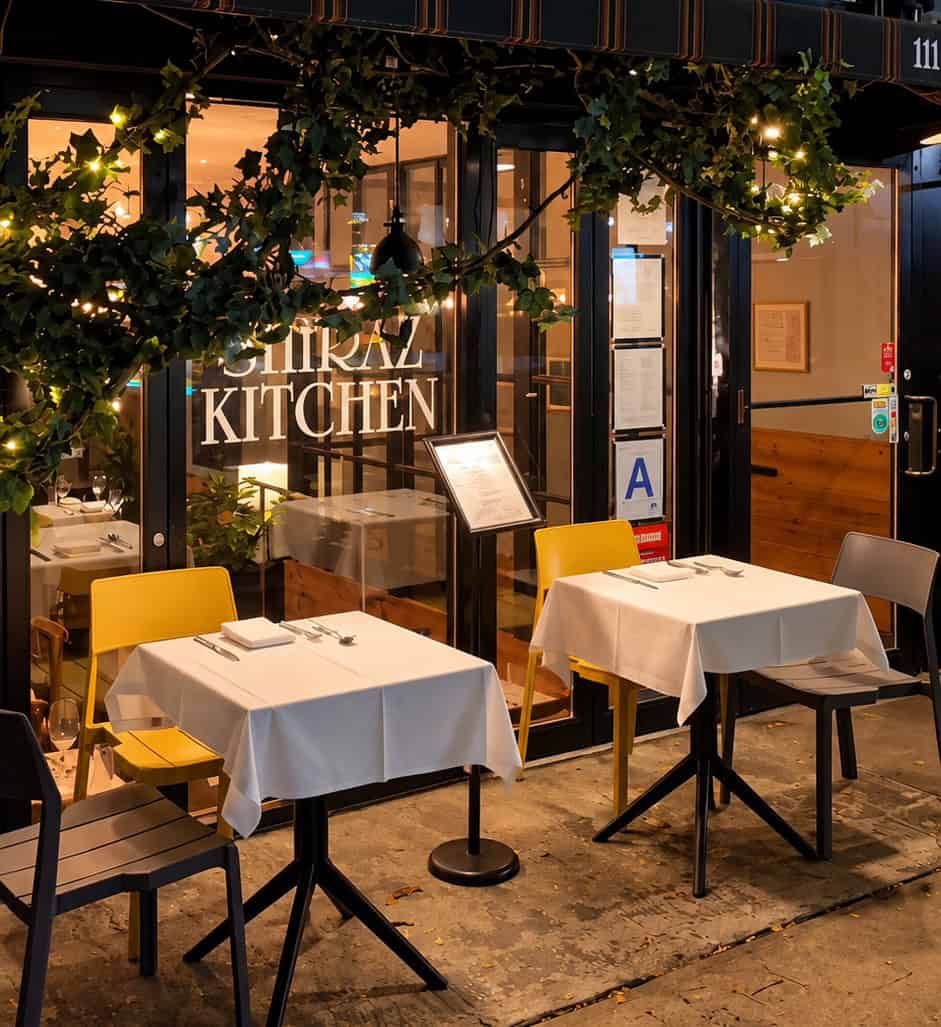 Exterior storefront of Shiraz Kitchen and Wine Bar on West 17th Street in Manhattan with outdoor tables