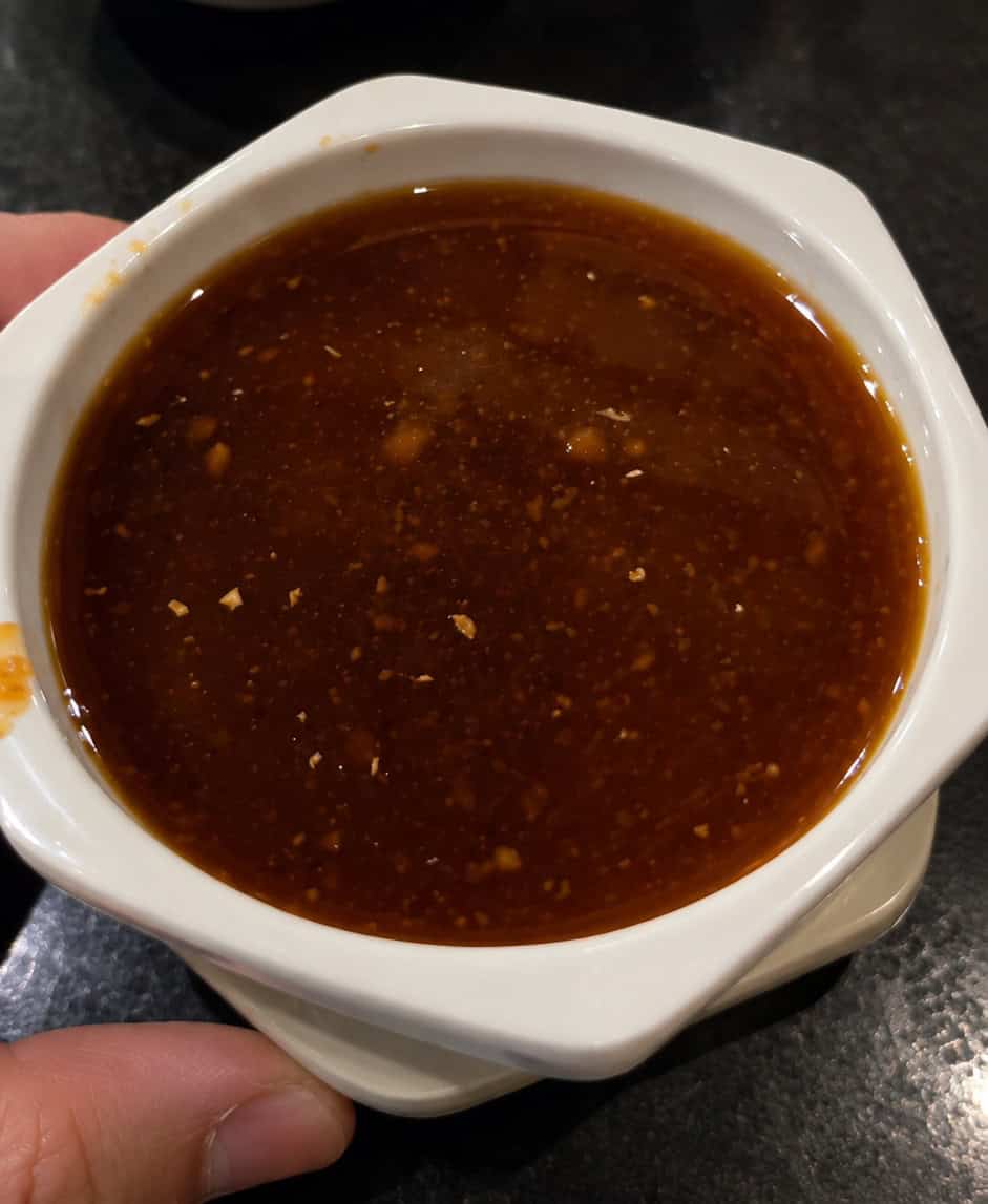 Close up of house ginger dipping sauce served in a square ceramic bowl at Shogun Hibachi
