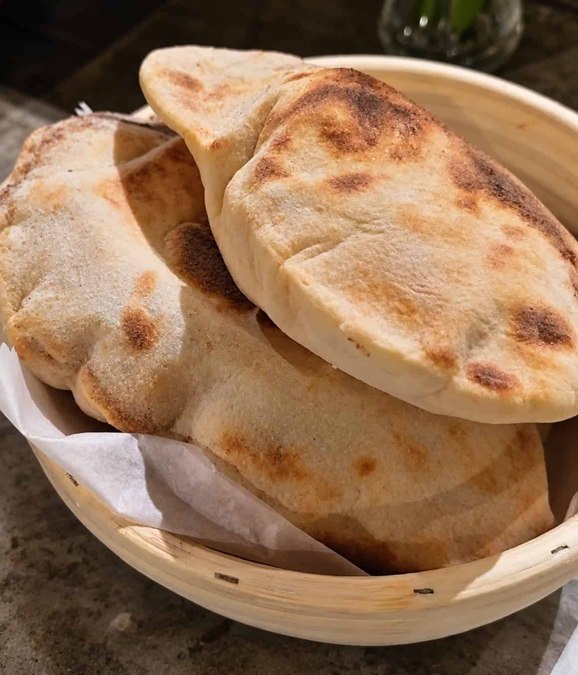 fresh Palestinian khubz bread served on a wooden plate