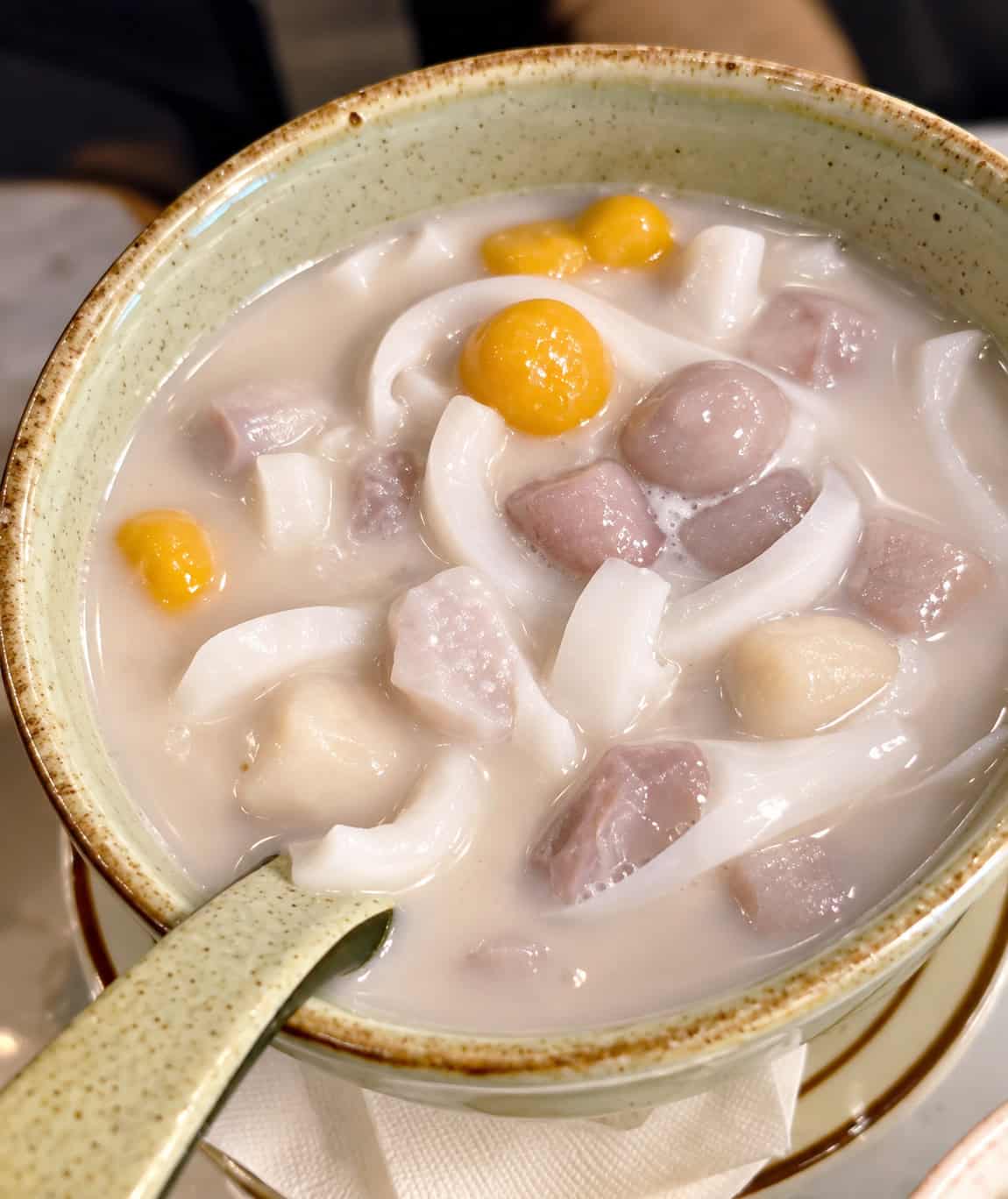 Traditional Thai Bua Loy dessert with taro rice balls and salted egg yolk in warm coconut milk