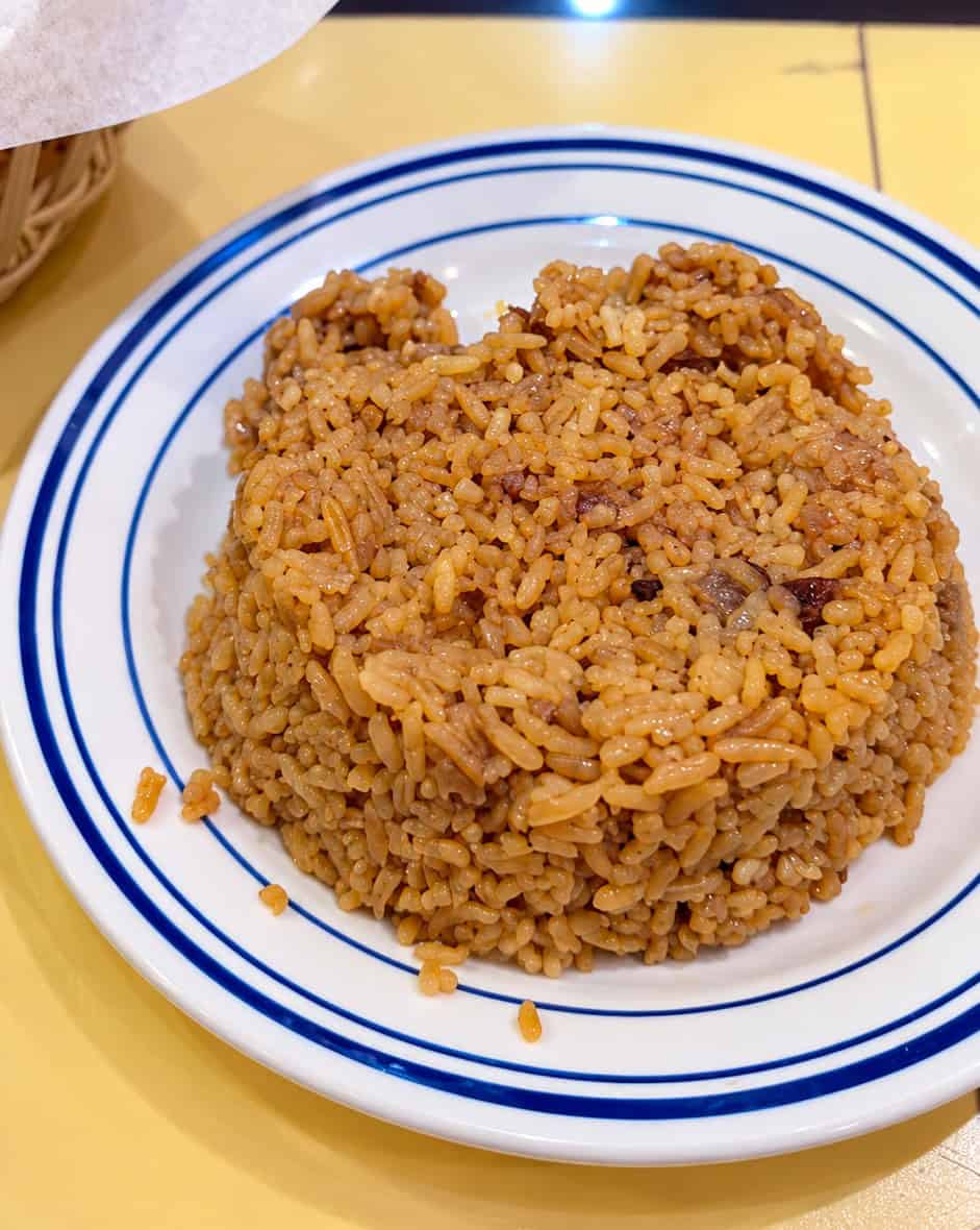 Mound of seasoned Egyptian brown rice on a blue rimmed plate
