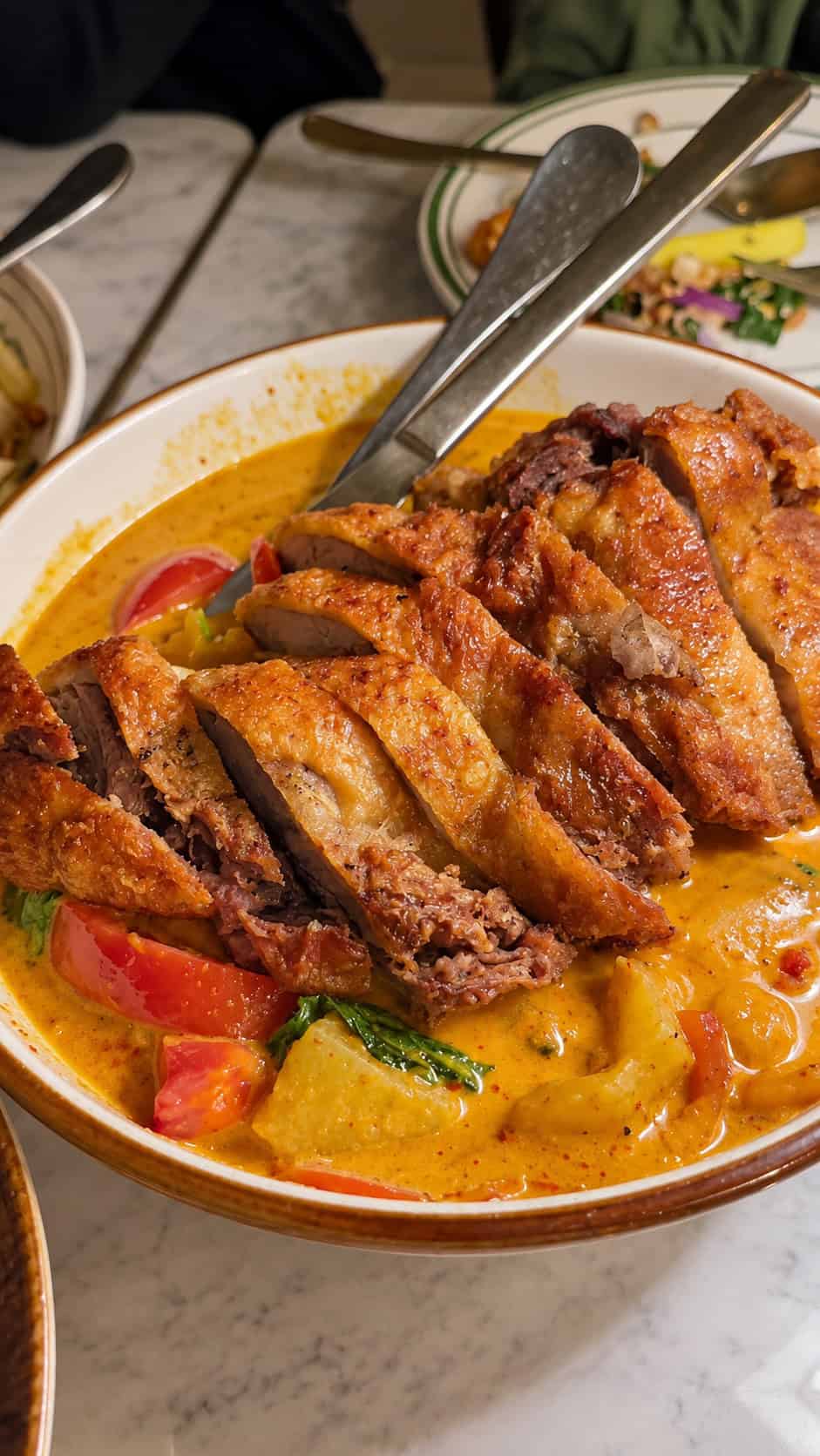 Sliced crispy duck breast served in rich red curry broth with pineapple and tomatoes